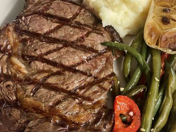 grilled sirloin steak with mashed potatoes and green beans